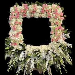 Large floral wreath of pink and white roses with cascading white flowers