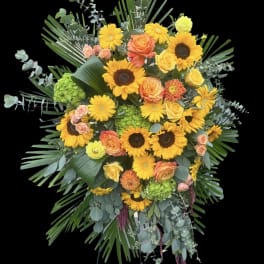 Large standing floral spray with sunflowers, roses, and greenery on an easel