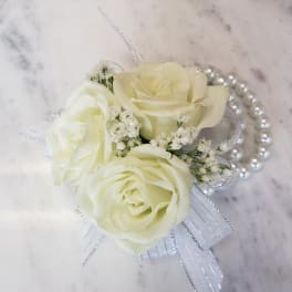 White rose corsage with pearl accents and ribbon