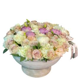 Pastel roses and peonies arranged in a low pedestal bowl
