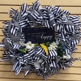 Blue-and-white ribbon wreath with small daisies and a happy sign