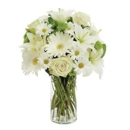 White lilies, daisies, and a rose in a clear glass vase