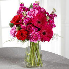 Bouquet of pink and red flowers in a clear glass vase