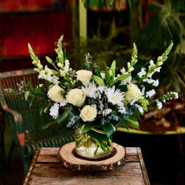 White roses and lilies in a glass vase with white snapdragons and daisies