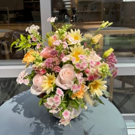 Mixed pastel bouquet in a white vase with roses and daisies