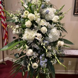 Large white floral standing arrangement with roses and orchids