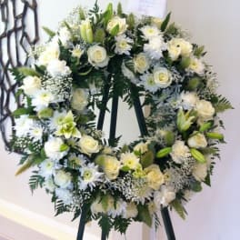 White floral wreath on a black easel
