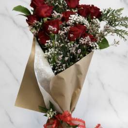 Bouquet of red roses with baby's breath in brown paper wrap
