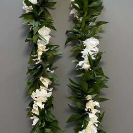 White flower lei with dense green leaves on a gray background