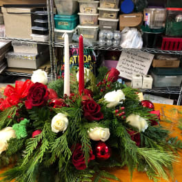 Holiday centerpiece with red and white roses and two taper candles