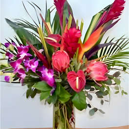 Tropical bouquet with pink orchids and red bird-of-paradise in a glass vase