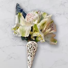 White and pale pink floral boutonniere with a jeweled cone holder
