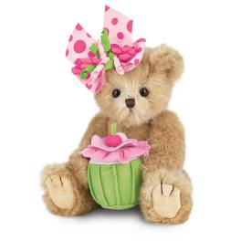 Teddy bear holding a pink flower pot and wearing a pink polka-dot bow