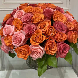 Bouquet of orange and pink roses in a clear glass vase