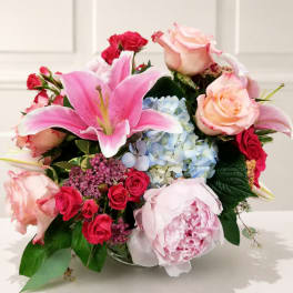 Mixed bouquet with pink lilies, roses, hydrangea, and peonies in a vase