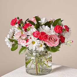 Pink roses and carnations with white daisies in a glass vase
