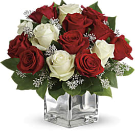 Red and white roses arranged in a clear glass vase