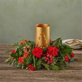 Red floral centerpiece around a gold candle holder
