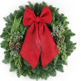 Evergreen wreath with pinecones, white berries, and a large red bow