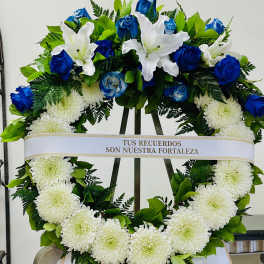 Heart-shaped funeral wreath with white chrysanthemums, blue roses, and white lilies