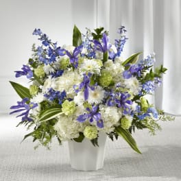 White and purple floral arrangement in a white vase