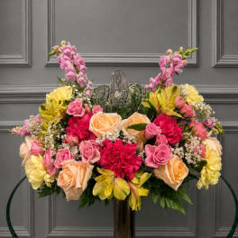 Large floral arrangement with pink, peach, and yellow flowers in a vase