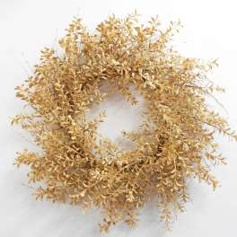 Dried golden wreath with small clustered leaves on a white background