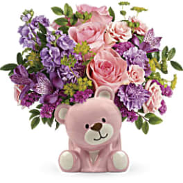 Pink and purple flower arrangement with a pink teddy bear container