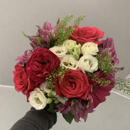 Handheld bouquet of red and white roses with purple flowers