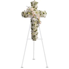 White floral cross on a white easel stand