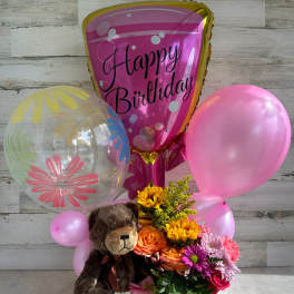 Birthday balloon bouquet with flowers and a teddy bear