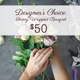 Hand-tied bouquet of pale roses with a price sign above it