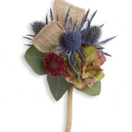 Small boutonniere with blue thistle, burgundy bloom, and hydrangea