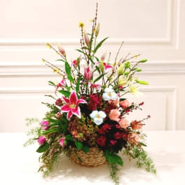 Tall mixed flower basket with lilies, roses, and pink blooms