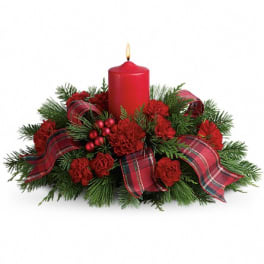 Red candle centerpiece with plaid ribbon and evergreen accents
