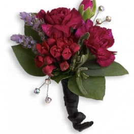 Magenta and red floral bouquet with green leaves and jeweled accents