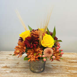 Fall bouquet in a decorative metal pot with yellow roses and orange chrysanthemums