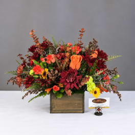 Autumn floral arrangement in a wooden box with orange and burgundy blooms