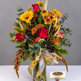 Mixed bouquet of red roses and sunflowers in a glass vase