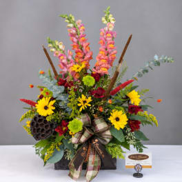 Mixed bouquet with pink snapdragons, yellow daisies, and a plaid ribbon in a black container