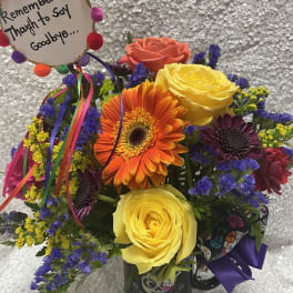 Colorful mixed bouquet in a decorated mug with a memorial sign