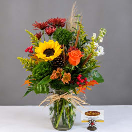 Mixed bouquet in a glass vase with a sunflower and orange rose