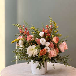 Mixed pink and white flower arrangement in a white vase