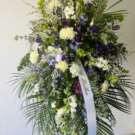 Tall standing floral spray with purple, white, and green blooms