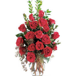 Tall bouquet of red roses in a clear glass vase