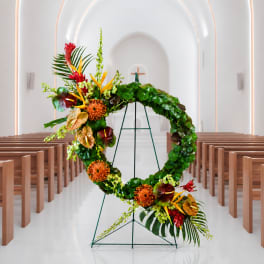 Large floral wreath on a stand in a church aisle
