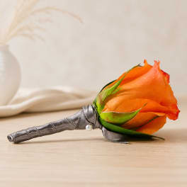 Orange rose boutonniere with gray ribbon wrap and pearl pin