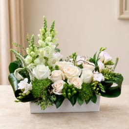 White and blush roses arranged in a rectangular white vase