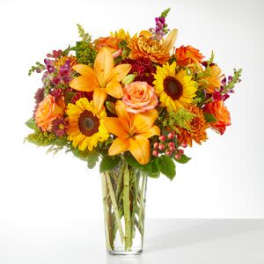 Bouquet of orange and yellow flowers in a clear glass vase