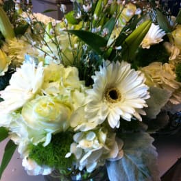 White and pale yellow floral arrangement in a glass vase